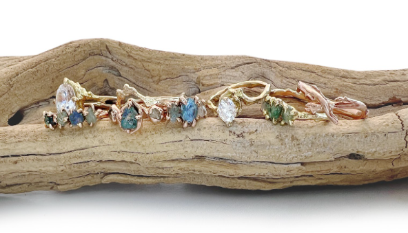 various sapphire and diamond engagement rings on a weathered branch various sapphire and diamond engagement rings on a weathered branch