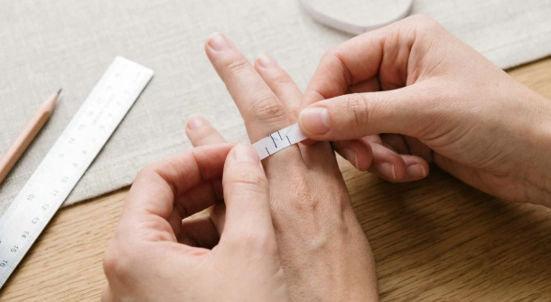 person trying on a paper ring sizer at home