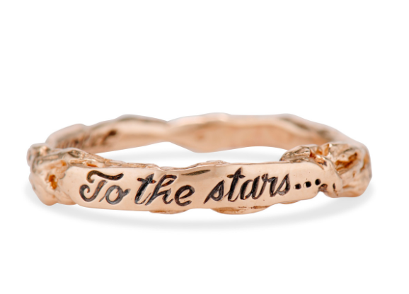 A gold, nature inspired band engraved with the phrase, "To the Stars" 